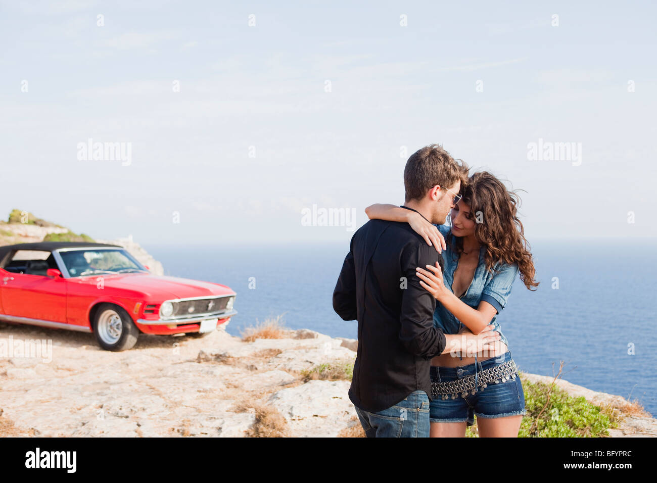 couple standing at cliff in front of car Stock Photo