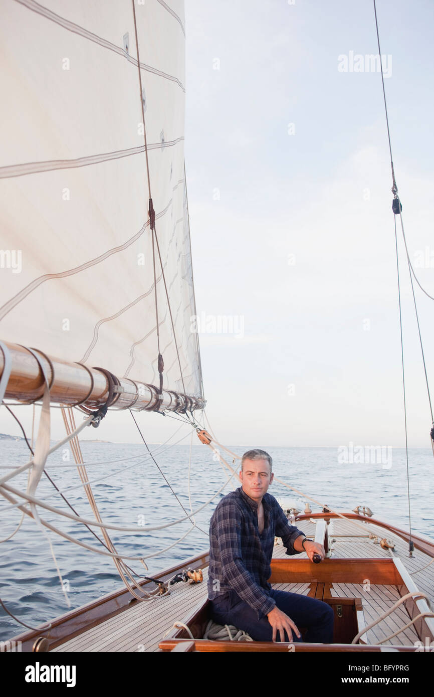man steering a sailing boat Stock Photo