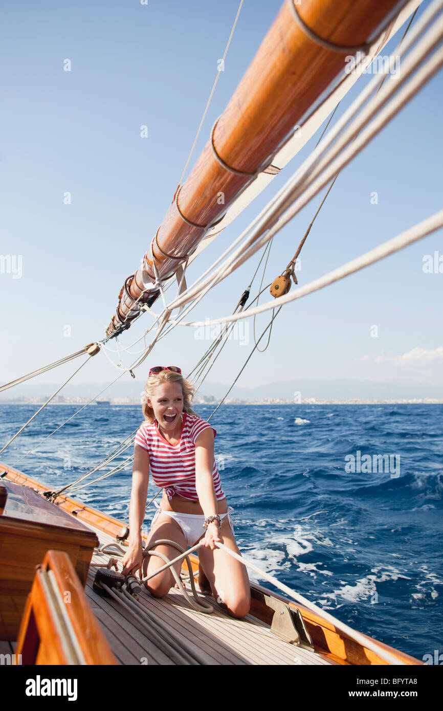 woman holding on to ropes on deck Stock Photo