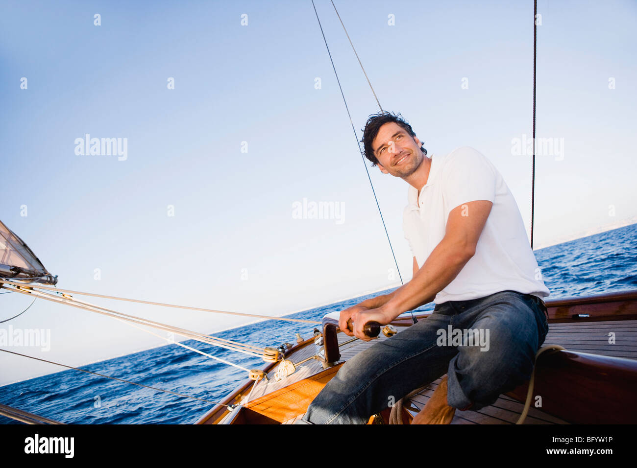 man steering a sailing boat Stock Photo - Alamy