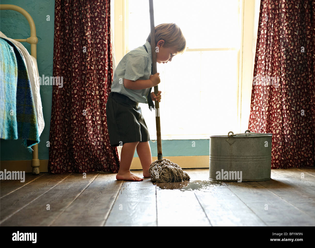 Toddler in school uniform cleaning floor Stock Photo Alamy