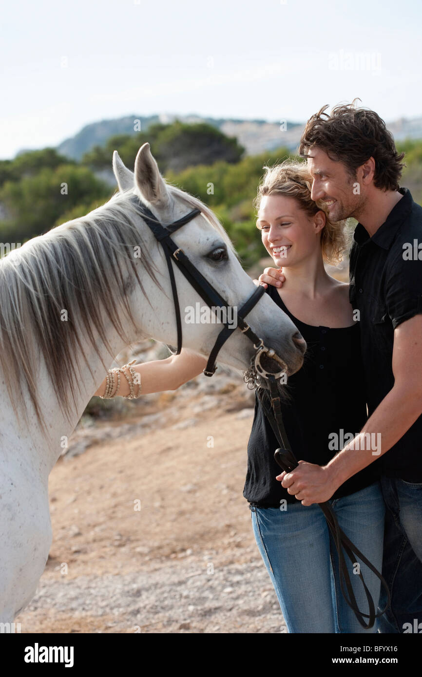 couple smiling holding horse Stock Photo