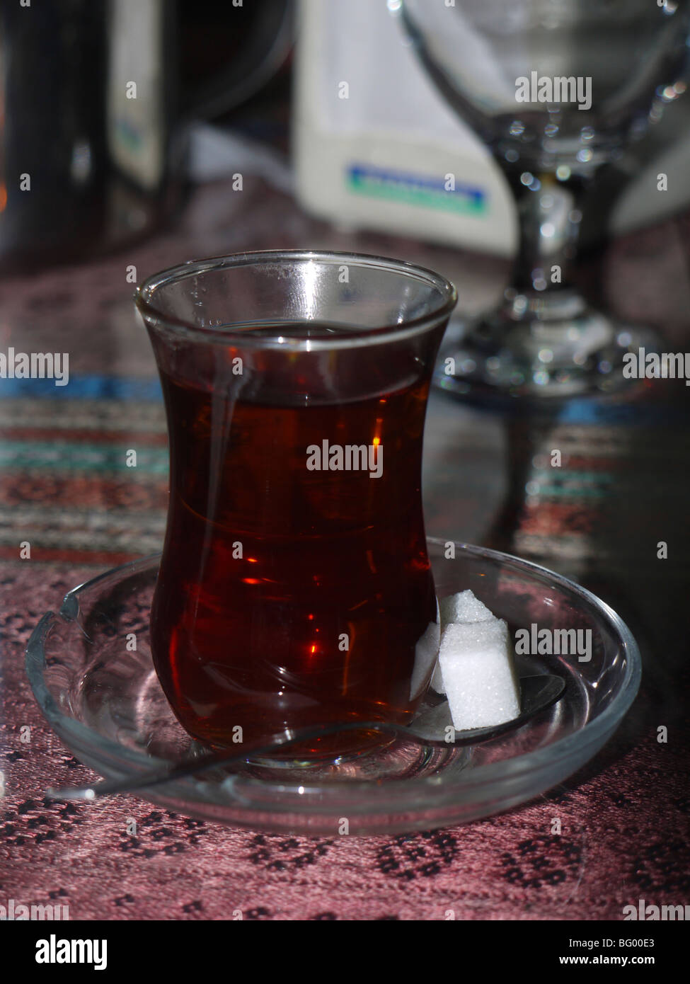 A glass of strong Turkish tea with lumps of sugar Stock Photo