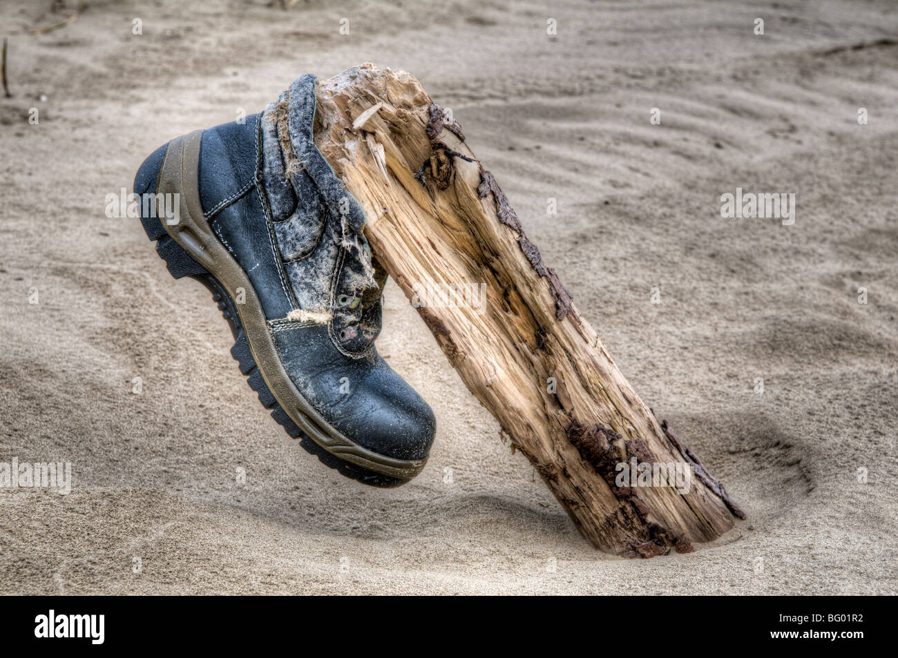 Walking boot thats been washed up on a beach and placed on driftwood at Pembrey, Wales Stock Photo