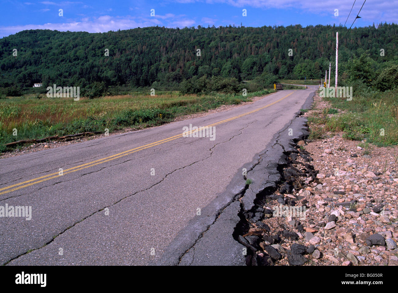 Dangerous Road Conditions - Soil Erosion along Side of Asphalt Highway creates Cracked and Broken Pavement Stock Photo