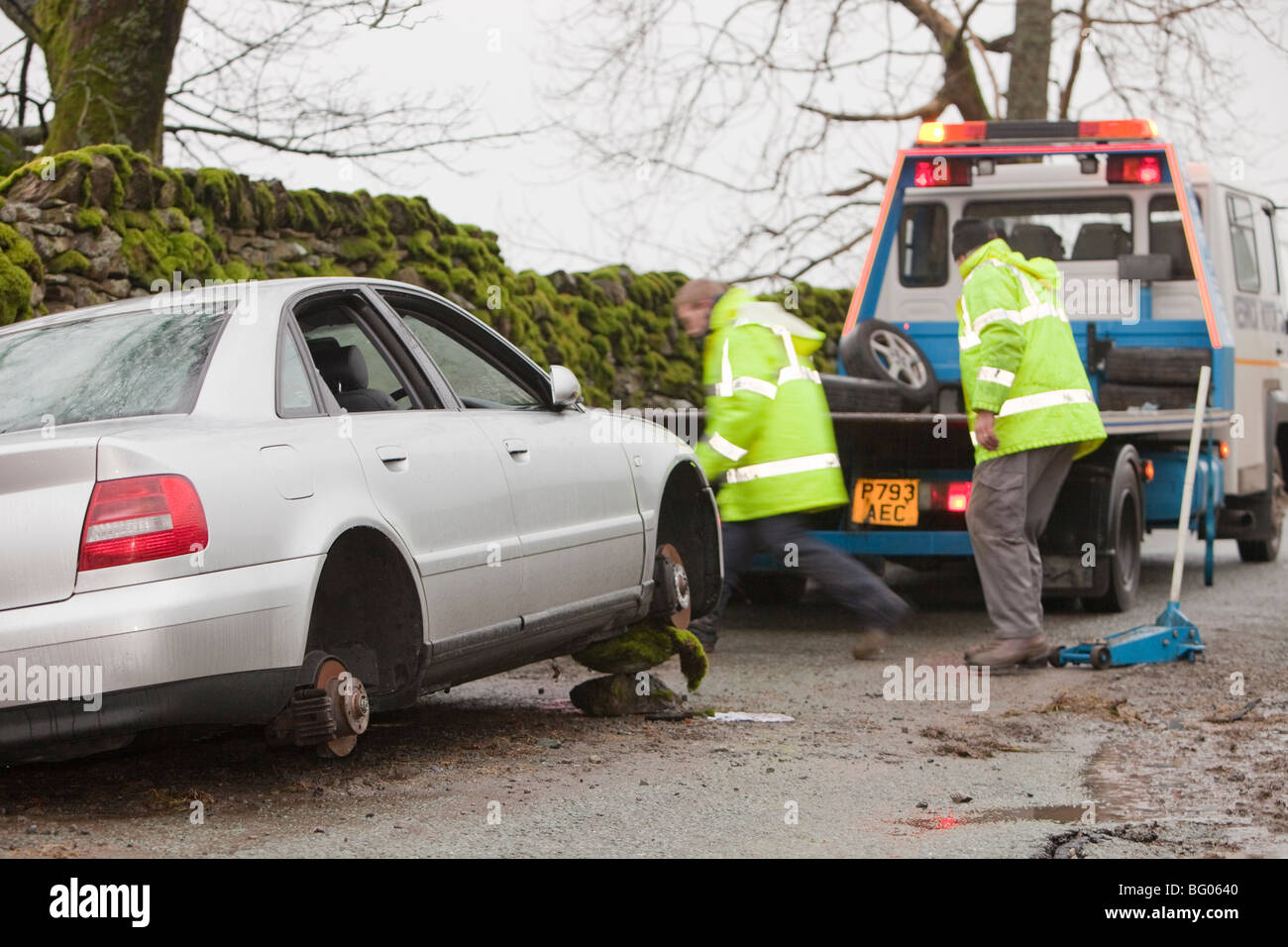 Removing a car that had its wheels stolen after being abandoned in the floods on kirkstone pass above Ambleside, Lake district, Stock Photo