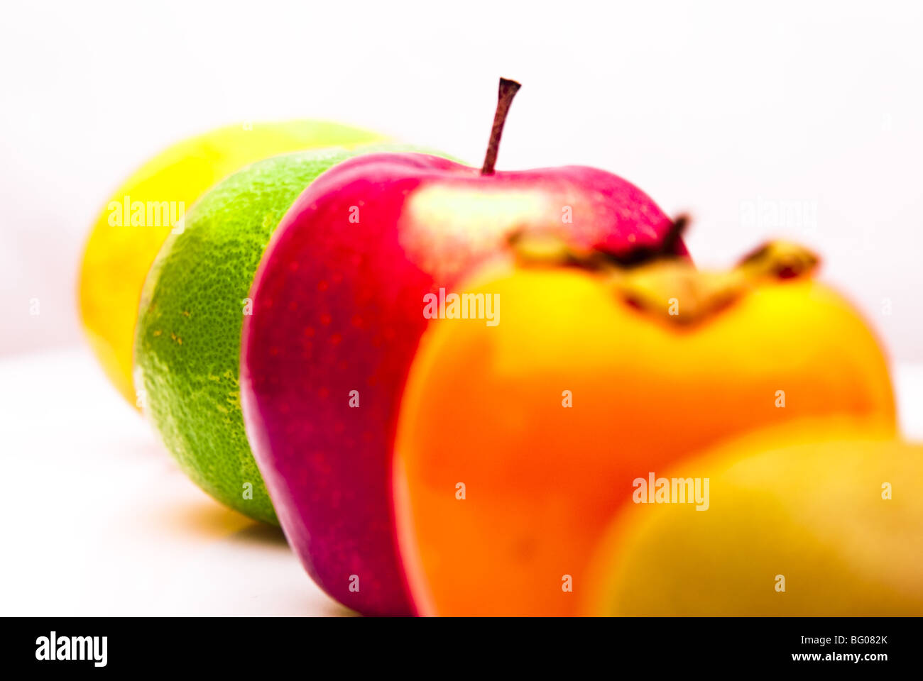 row of fresh fruits orange apple kiwi kaki grapefruit isolated Stock Photo