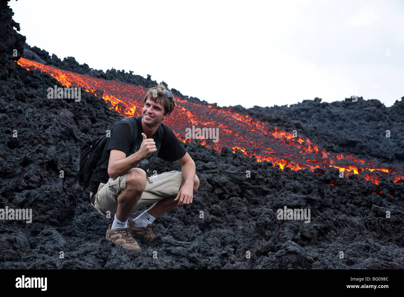 Flowing Lava and Tourists towards the Pacaya Volcano Peak. Volcan Pacaya National Park. Stock Photo