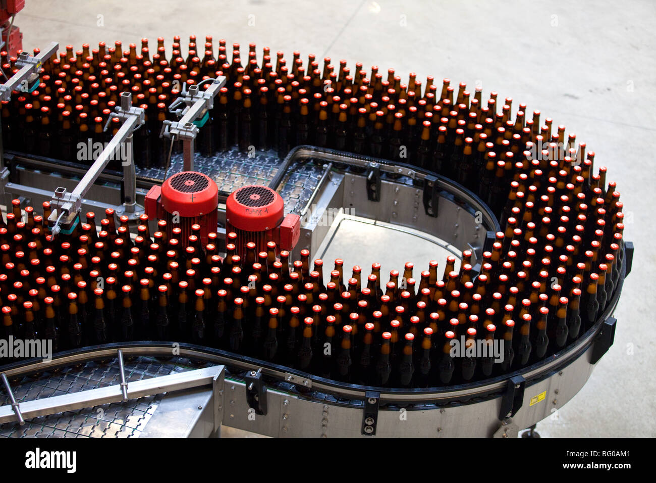 Filled bottles on conveyor belt in a brewery, Poland. Stock Photo
