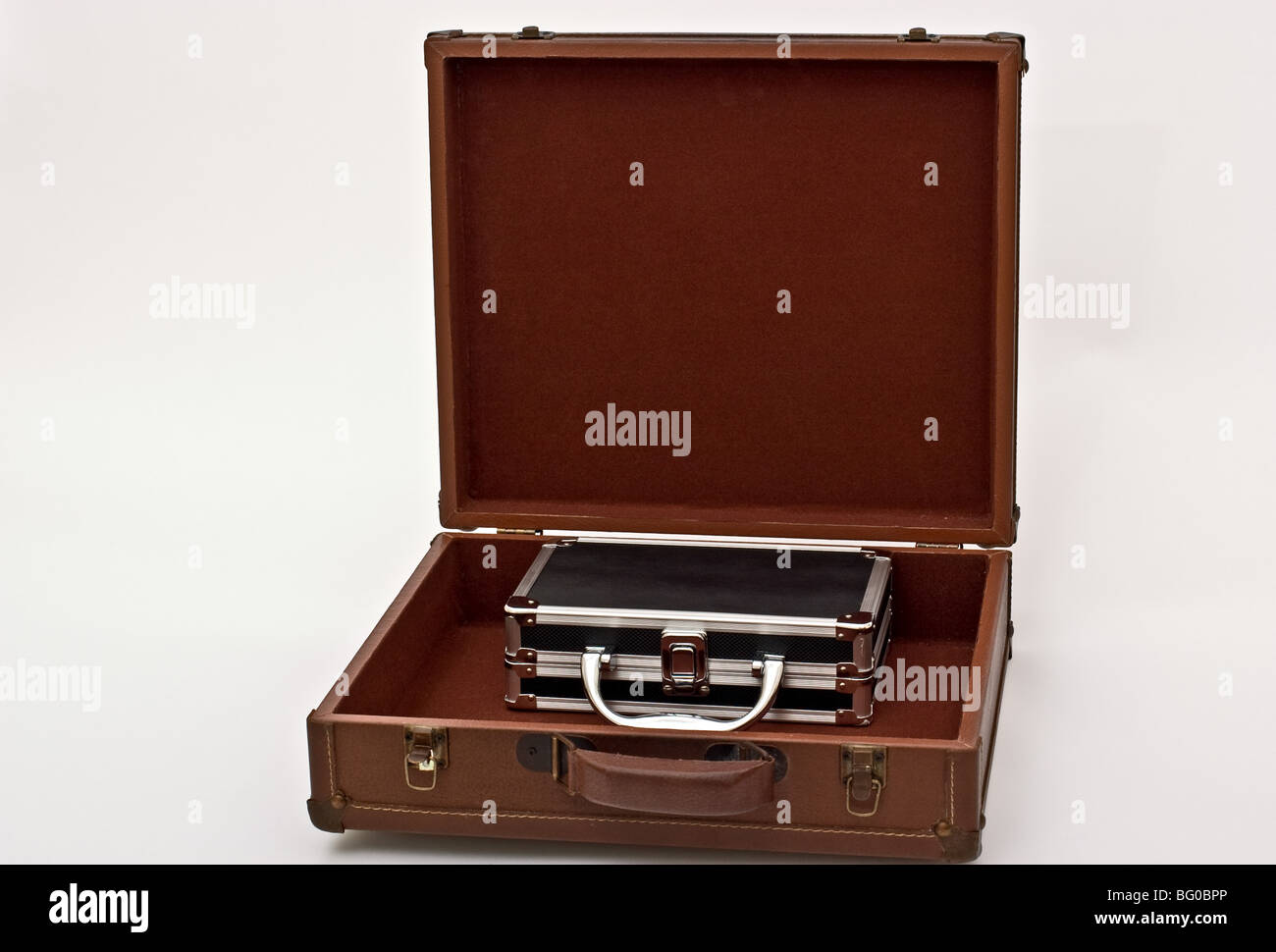 An open silver lined  black box inside a brown suitcase. Stock Photo