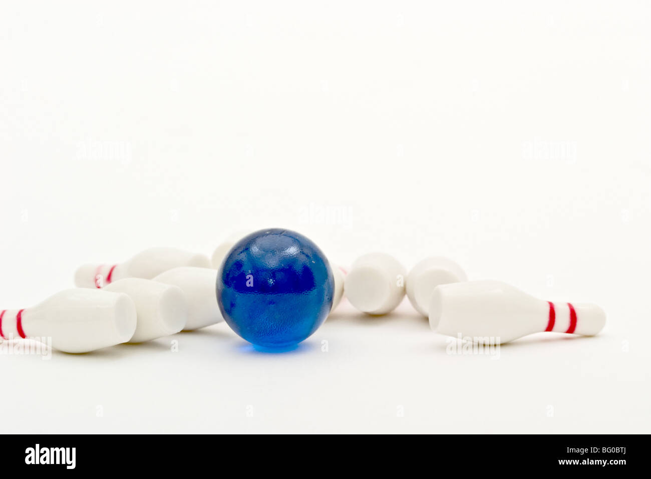 Small toy bowling ball in the midst of knocked over bowling pins Stock Photo Alamy