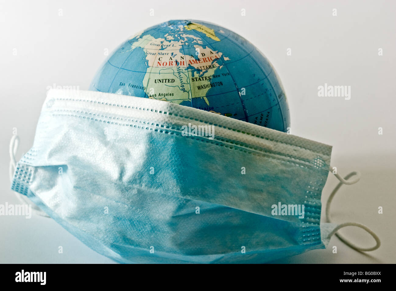 Medical mask covering a representation of the earth Stock Photo