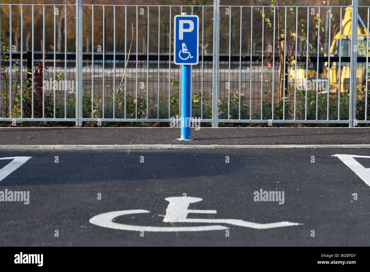 post with disabled parking sign in front of a parking bay in a car park in the uk ireland Stock Photo