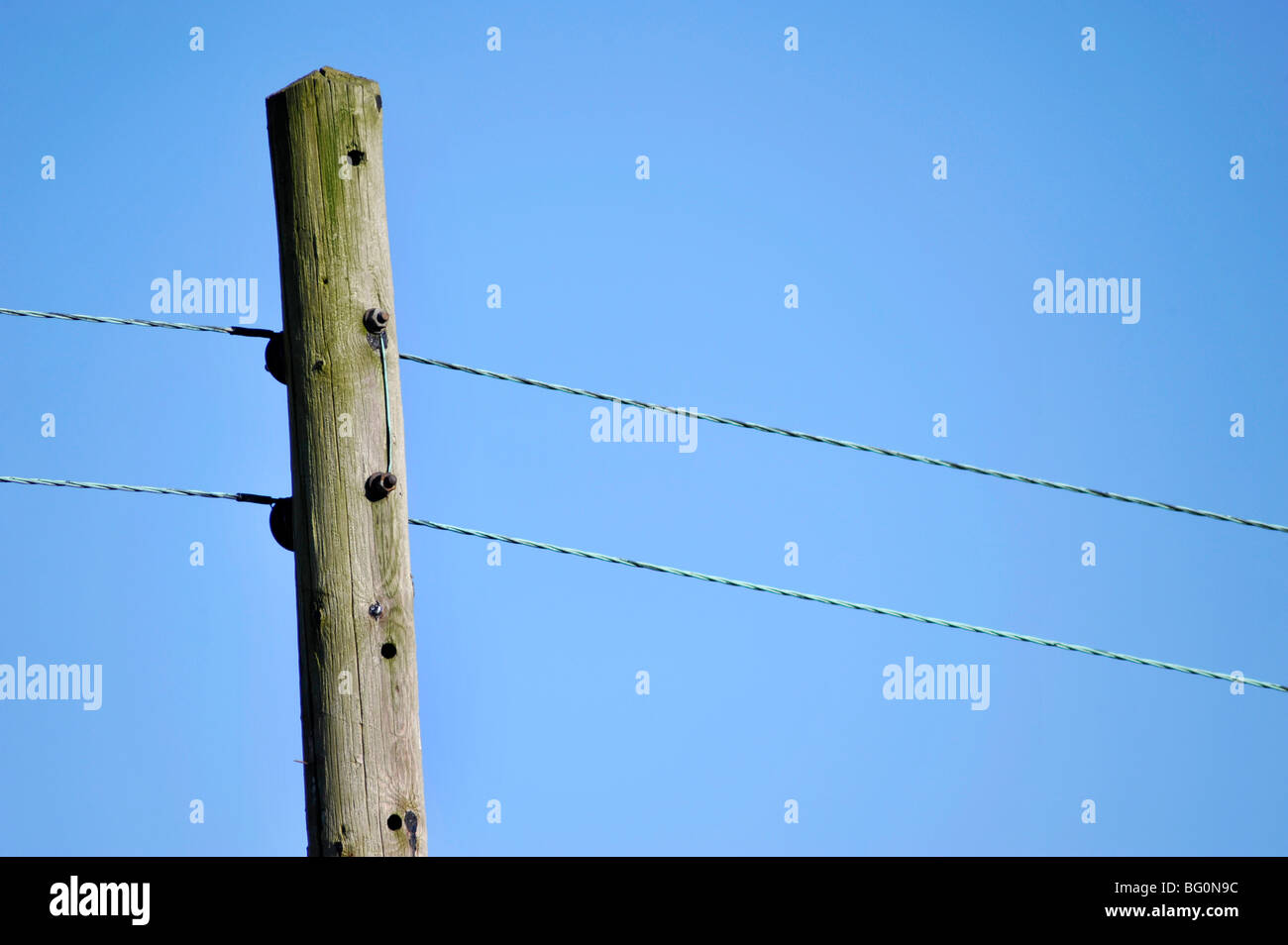 wooden post carrying electricity to rural area Stock Photo