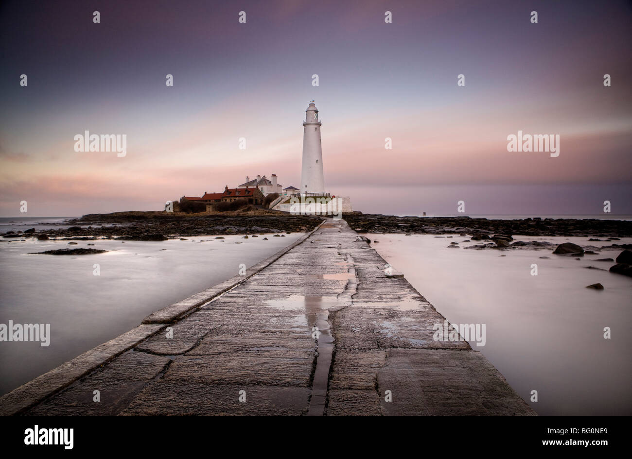 View along tidal causeway to St. Mary's Island and St. Mary's Lighthouse at dusk, Tyne and Wear, England, United Kingdom Stock Photo