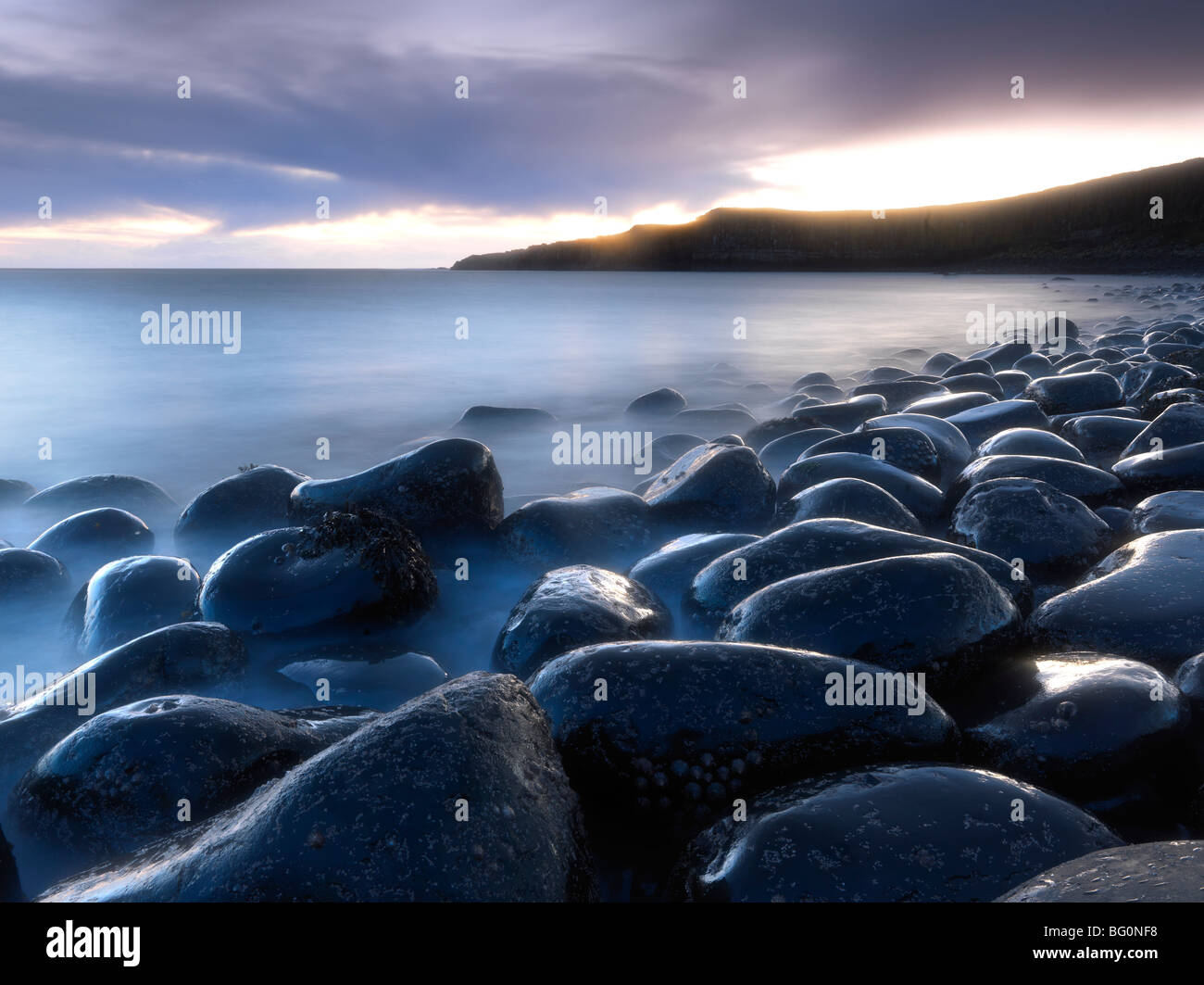 Embleton Bay at dawn from beach of basalt boulders known as The Rumble Churn, Northumberland, England, United Kingdom Stock Photo