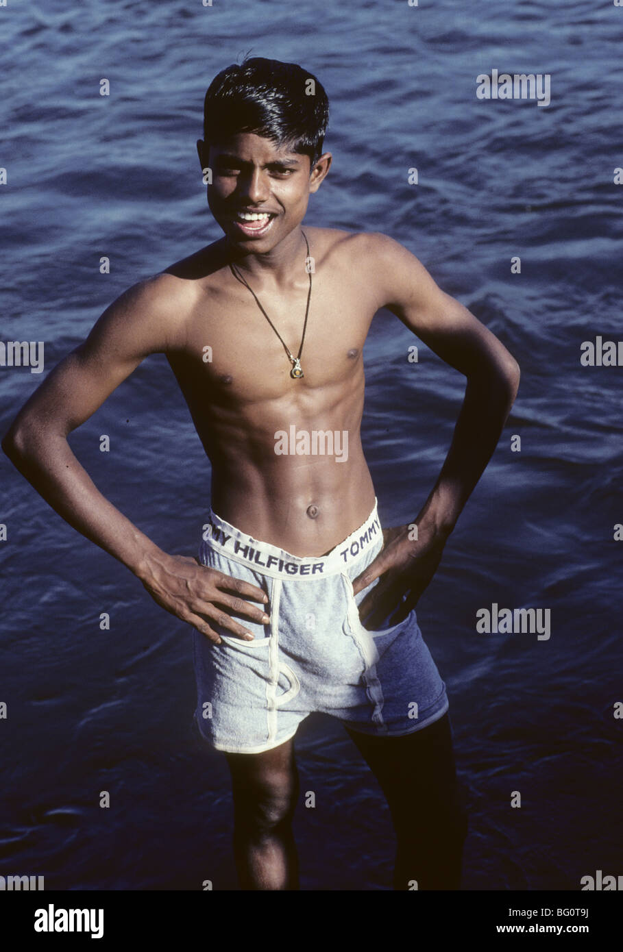 Portrait of a teen age boy wearing Tommy Hilfiger shorts in the Tungabhadha  River, Hampi, India Stock Photo - Alamy