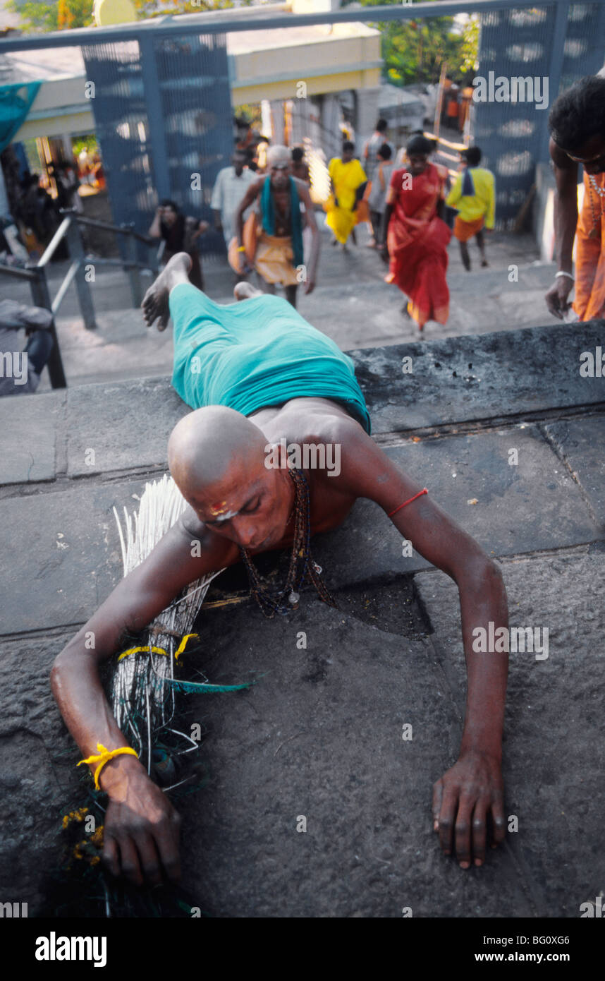 A fire walker/devotee gets put into a trance before walking on the hot coals in the village of Manjacombi in the South India state of Tamil Nadu. Fire walking is an important ritual practiced by certain sections of Hindu society. Fire walking is an act of self-purification. For some devotees it is a part of a vow in which the devotee promises to walk on fire in exchange for a wish or blessing granted by Amman. Amman is an important female deity associated with the Shakti cult in South Indian and Tamil culture. Stock Photo