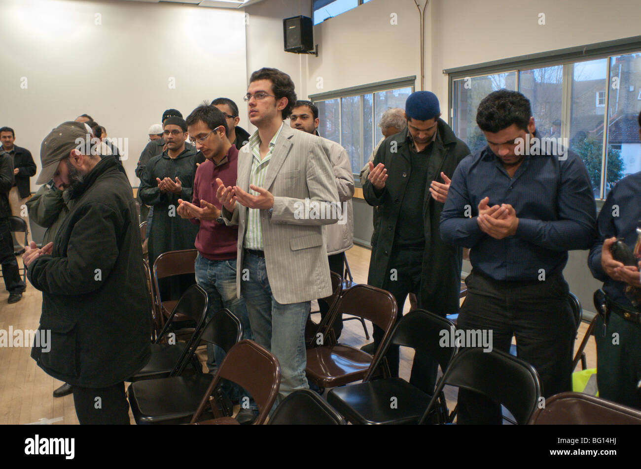 Men stand to pray in Eid Milad-Un-Nabi Celebrations at Sunni Muslim Association, Tooting, London. Stock Photo