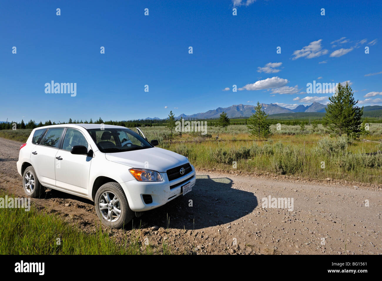 Car on a gravel road in the western part of Glacier national park Stock