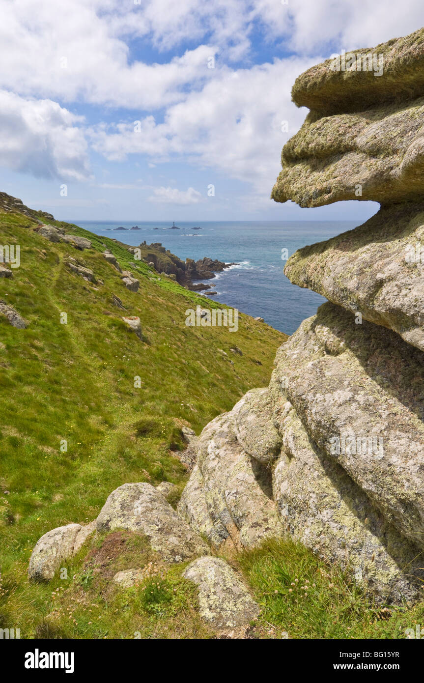 Part of the South West Coast Path at Mayon cliff showing the Longships lighthouse in the distance, Cornwall, England Stock Photo