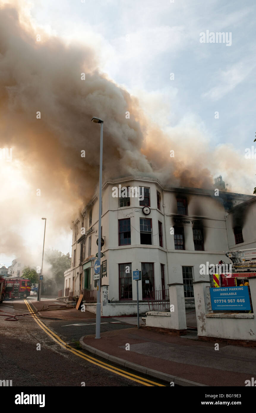 Pub hotel on fire with smoke issuing from roof Stock Photo