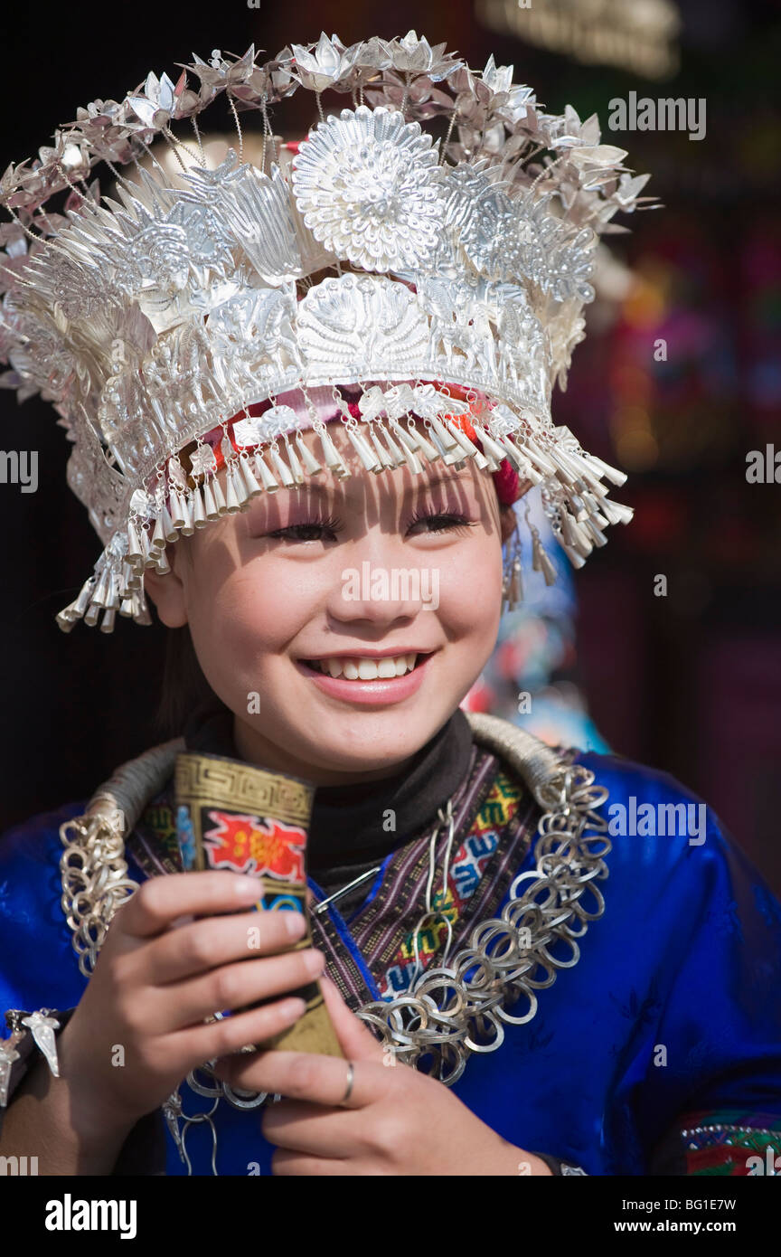 Girl welcoming visitors with a horn of rice wine at a Miao New Year festival in Xijiang, Guizhou Province, China Stock Photo