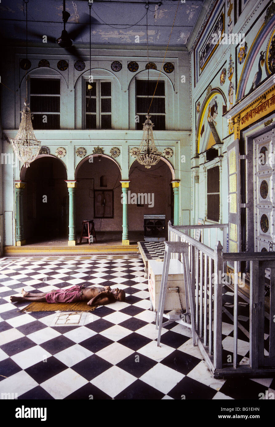 A man rests under a fan to get out of the heat of the sun in Mathura ...