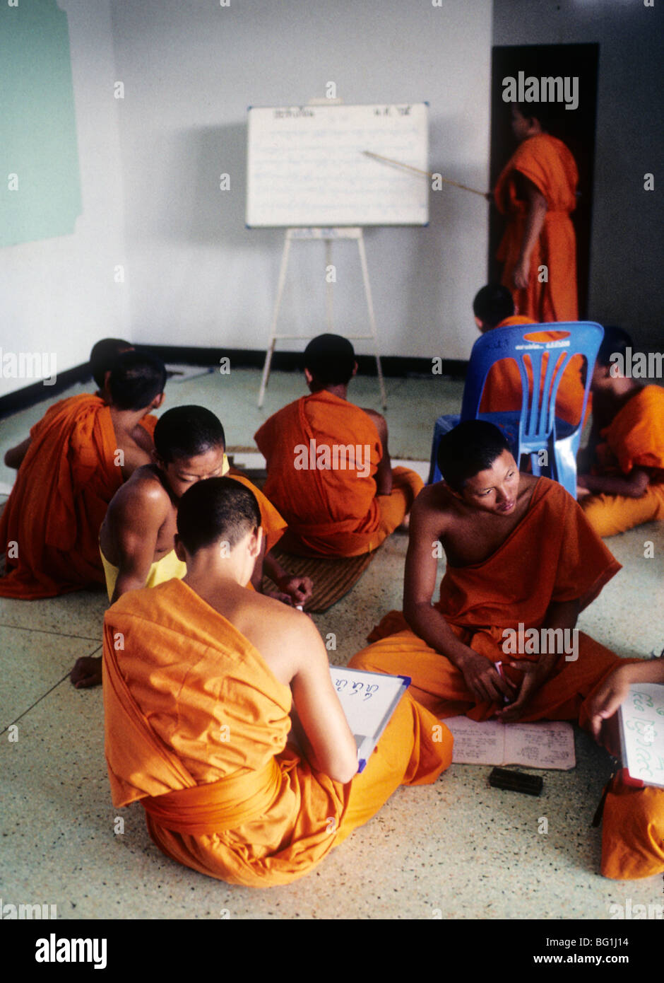 A Buddhist monk teaches the Buddhist principles to a class of young monk students in Chaing Rai, Thailand Stock Photo