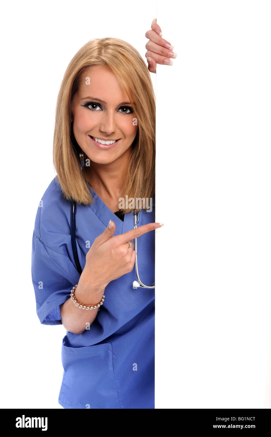 Health care worker pointing to blank sign Stock Photo