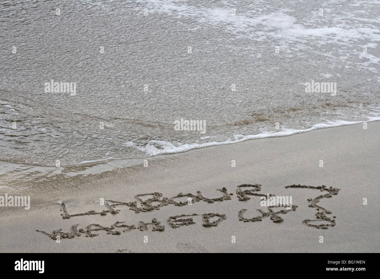 Labour washed up written in the sand with a turning tide. Symbolic Stock Photo