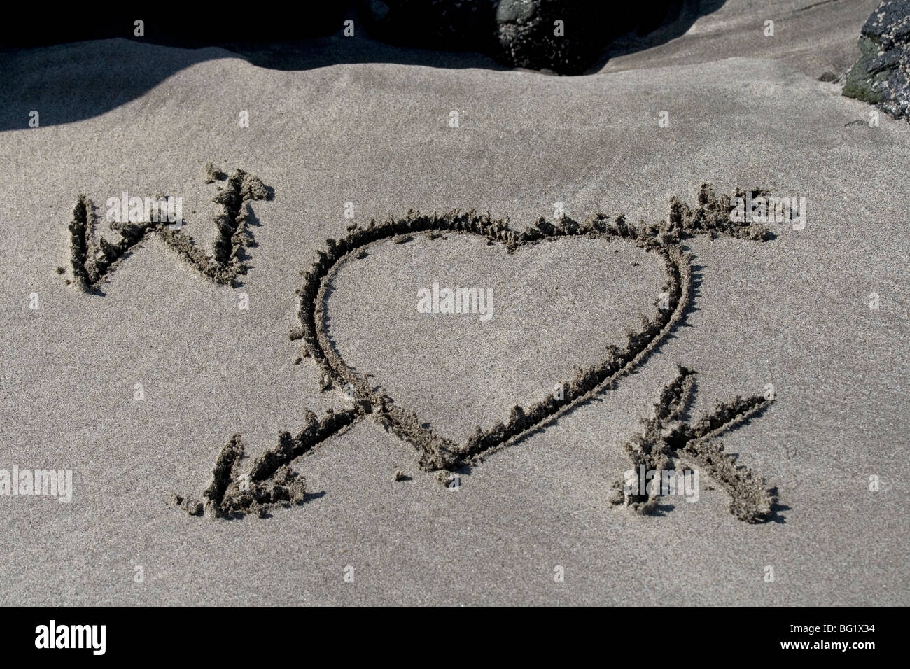 W and K, Prince William and Kate Middleton. Wills and Kate. A Royal romance. Love letters in the sand. Stock Photo
