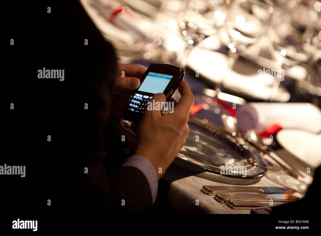 Man using Blackberry whilst at dinner event. Stock Photo