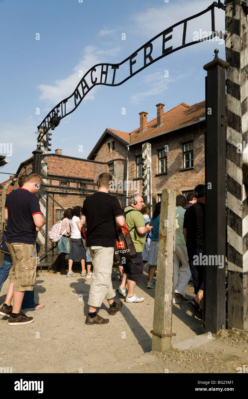 Tourists at the main entrance – with REAL Arbeit Macht Frei slogan above the gates – at Auschwitz Nazi camp in Oswiecim, Poland Stock Photo