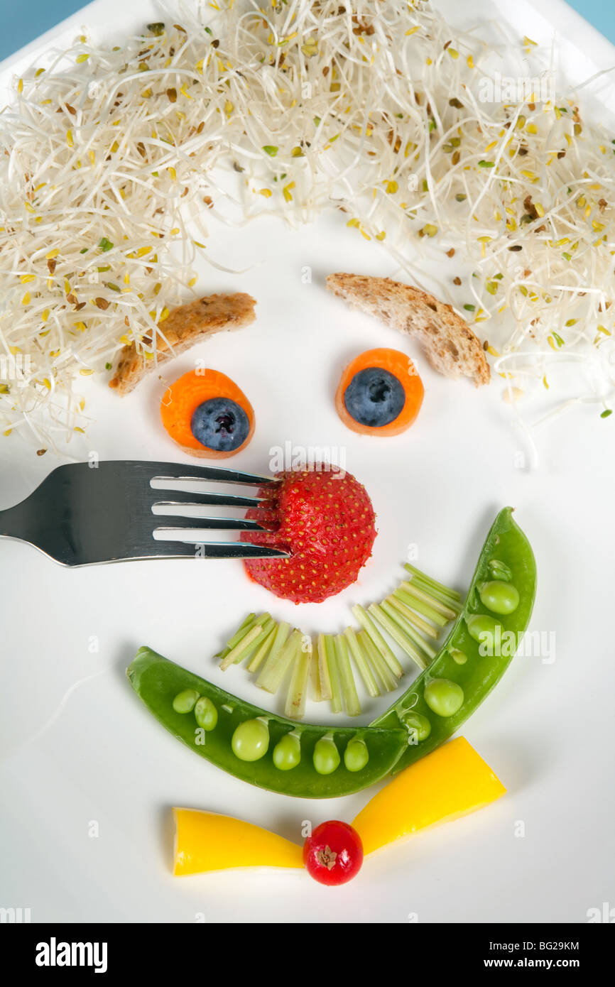 Funny food face with a fork in his strawberry nose Stock Photo Alamy