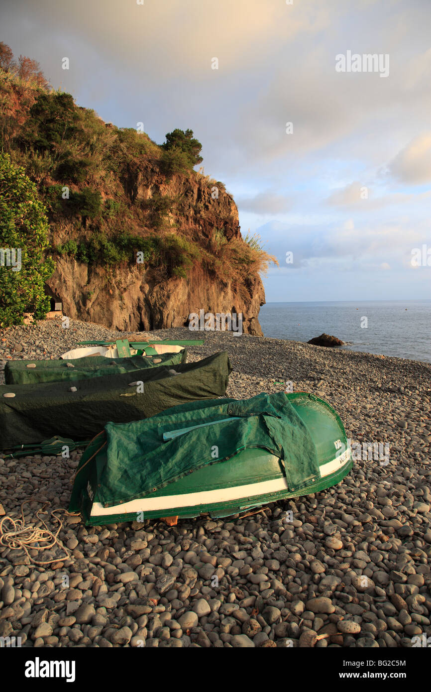 Beached fishing boat lying upside down at a pebble beach of Madeira ...