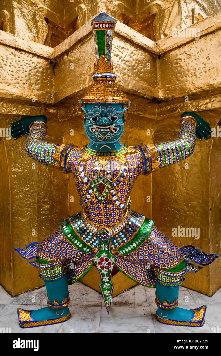 This colorful demon or Yaksha supports and guards the golden chedi at Wat Phra Kaew in the grounds of the Royal Palace Bangkok Stock Photo