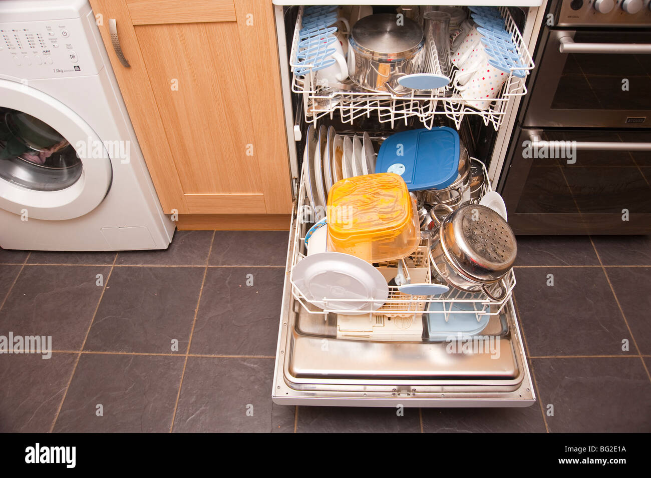 A dishwasher fully loaded with dirty dishes ready to be washed Stock