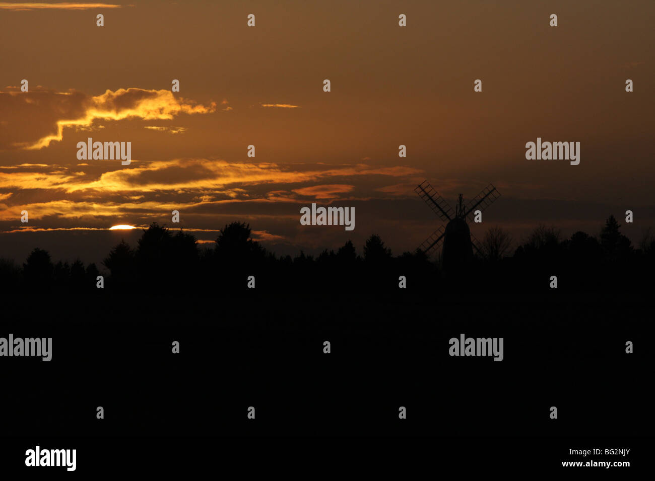 The sun setting behind one of the windmills in Swaffham Prior, Cambridgeshire, United Kingdom. Stock Photo