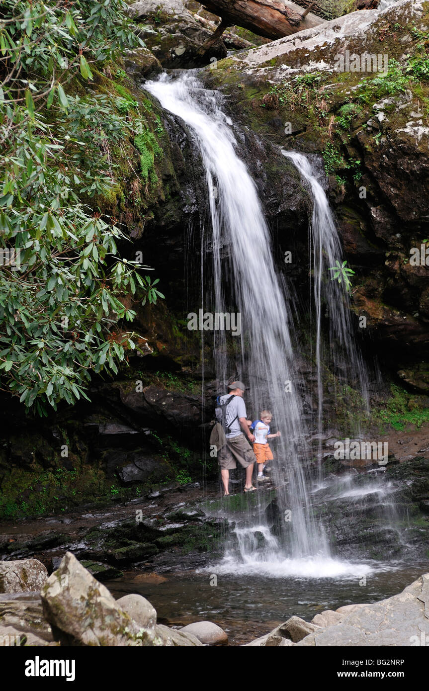 man and child walking behind Rainbow Falls on LeConte Creek in Great Smoky Mountains National Park. Gatlinburg, Tennessee USA Stock Photo