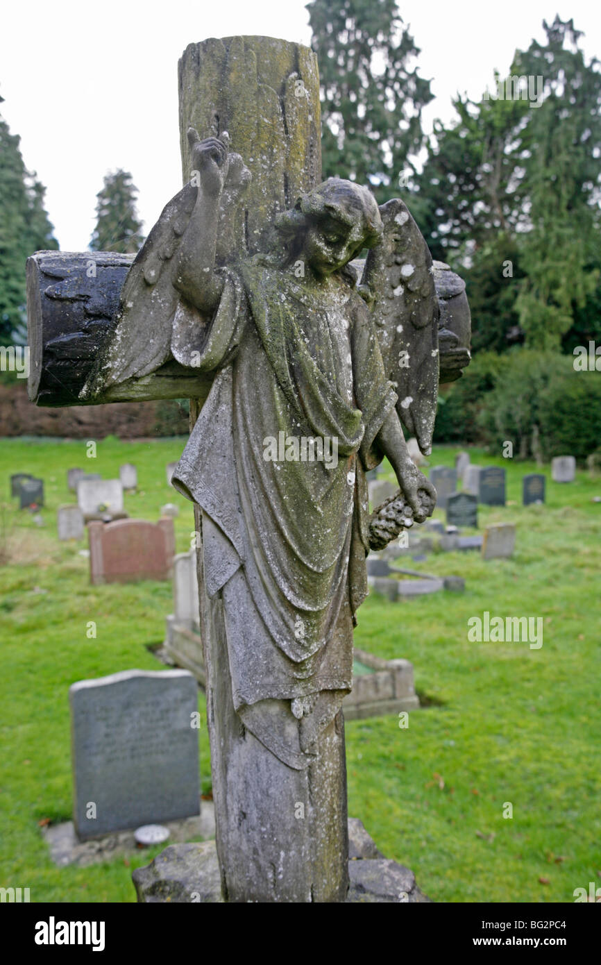 An Angel carved onto a stone cross marking a grave Stock Photo