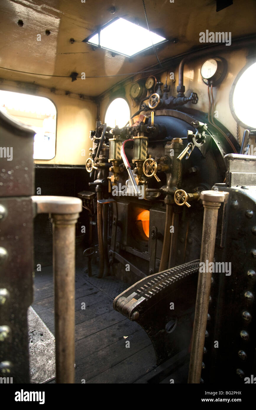 Footplate of steam locomotive with fire visible in firebox Stock Photo