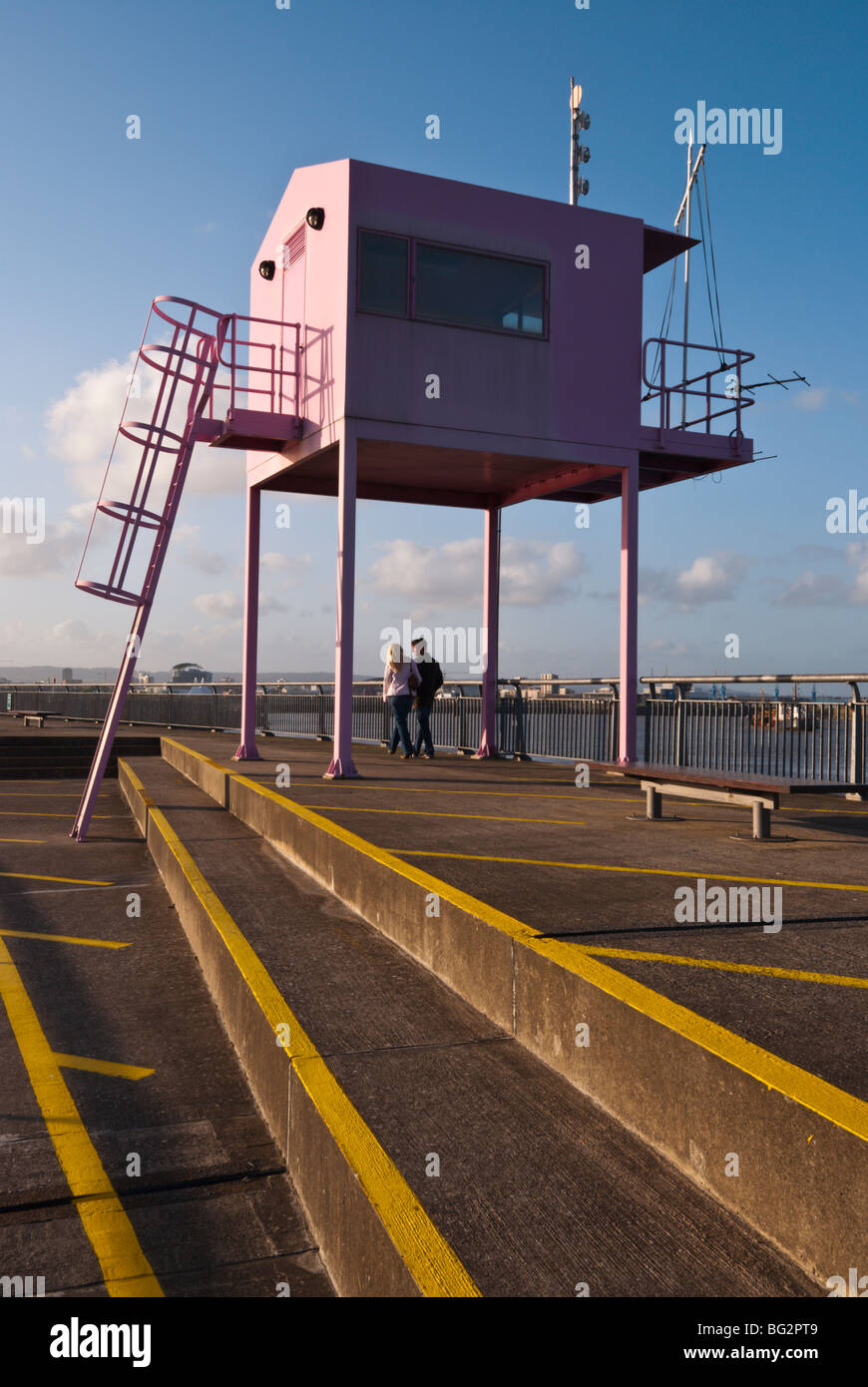 People walking under the pink watch tower  at Cardiff Bay, South Wales UK Stock Photo