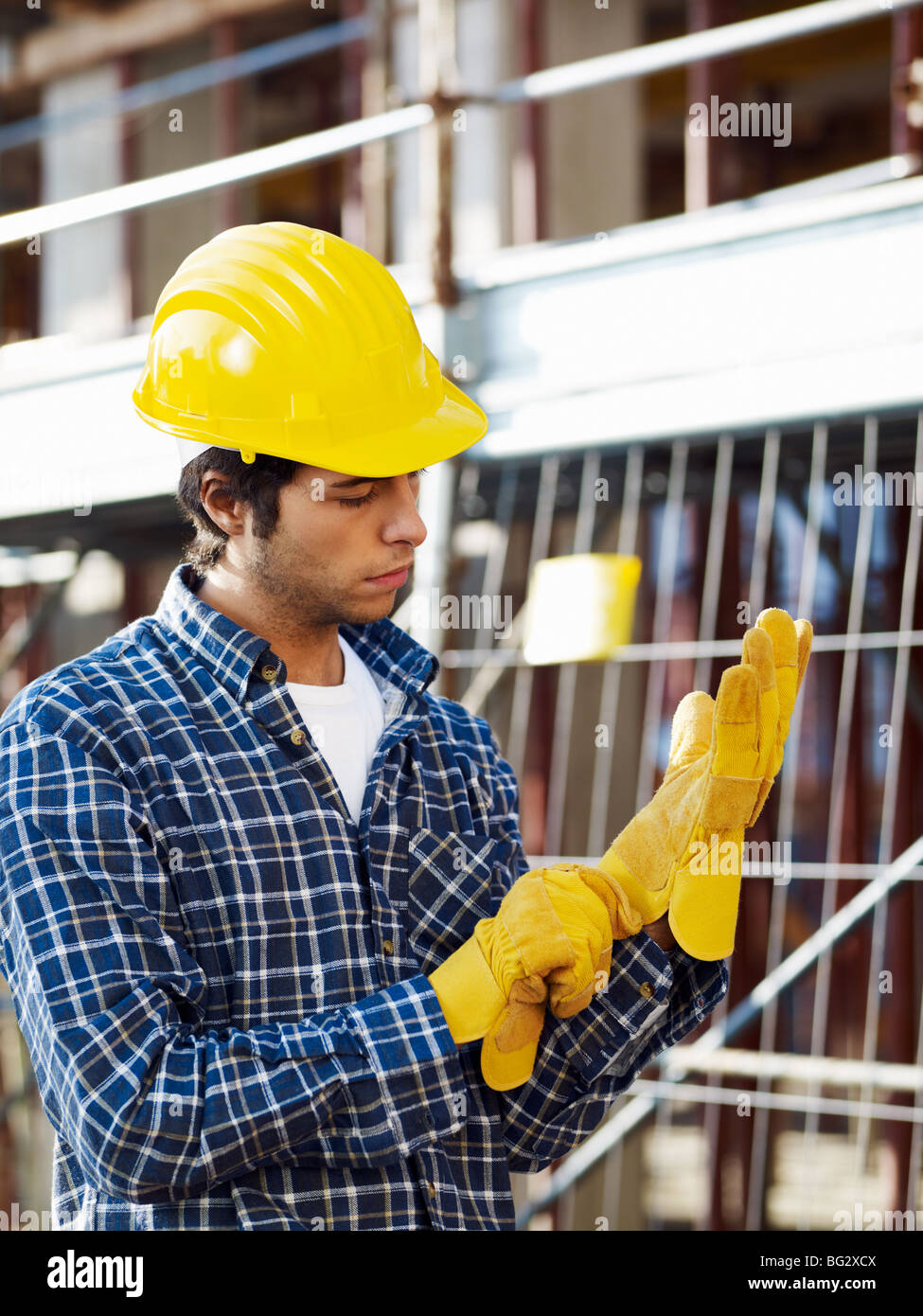 construction worker putting on protective gloves Stock Photo