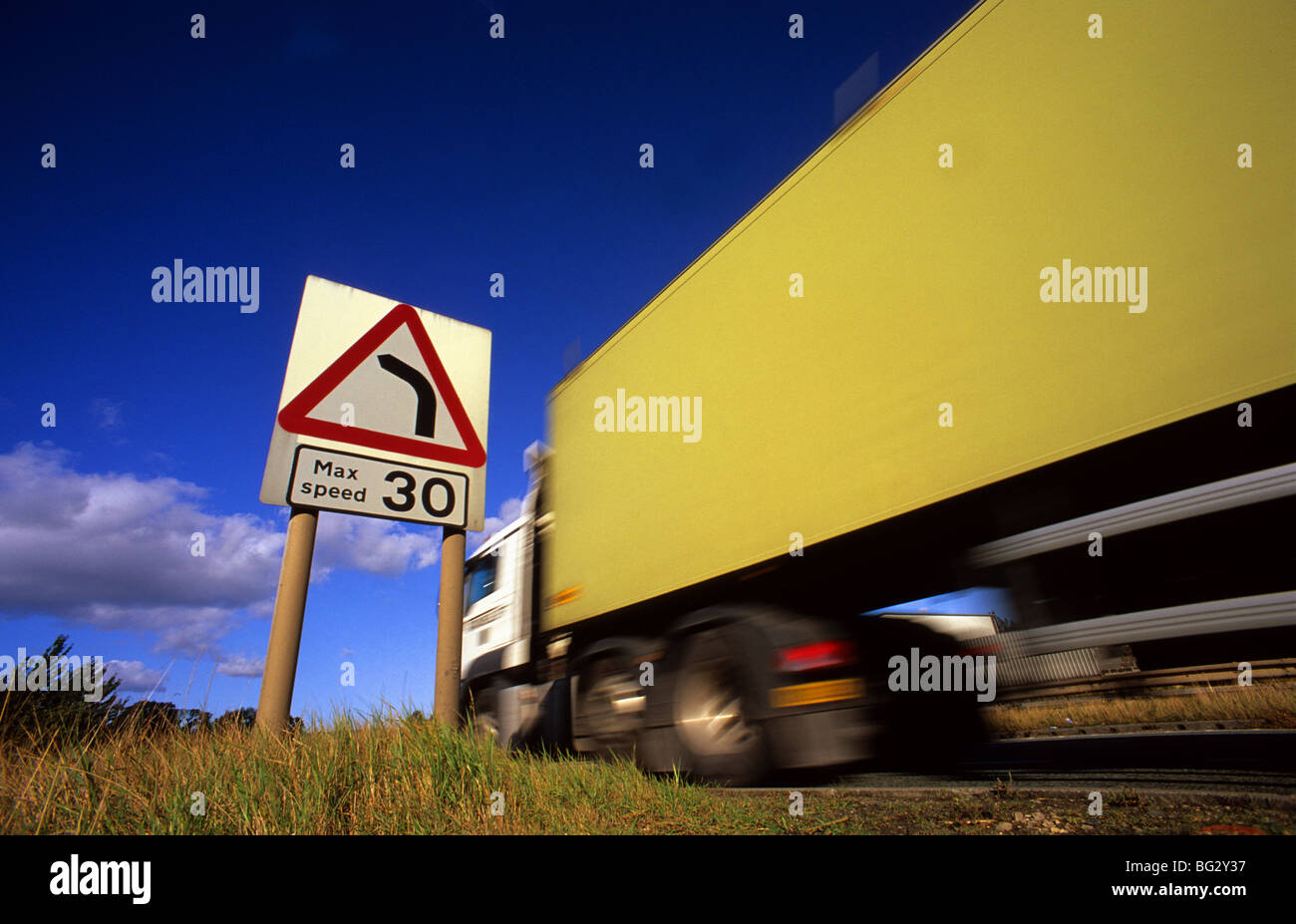 lorry passing warning sign of 30 mph speed limit and sharp left hand bend in the road ahead Ferrybridge yorkshire uk Stock Photo