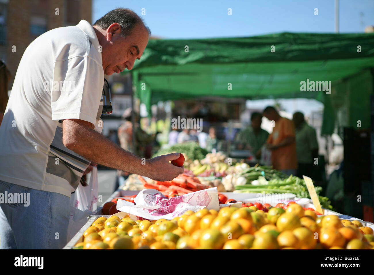 Man choosing tomatoes at a market stall in southern Spain Stock Photo