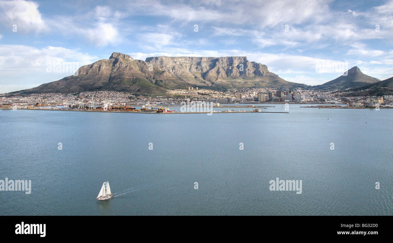 An aerial photograph of Cape Town and Table Mountain from the sea with a yacht sailing away from the land Stock Photo