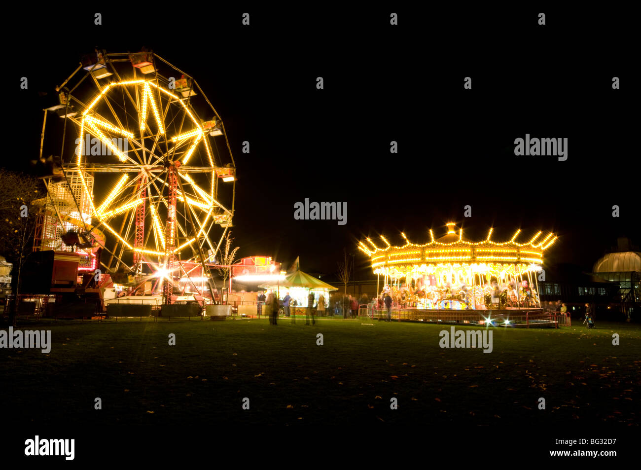 Funfair Rides Chesterfield Ferris wheel and Carousel lit up at night at a funfair in Chesterfield ...
