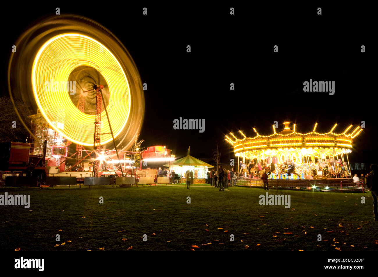 Funfair Rides Chesterfield Ferris wheel and Carousel lit up at night at a funfair in Chesterfield ...