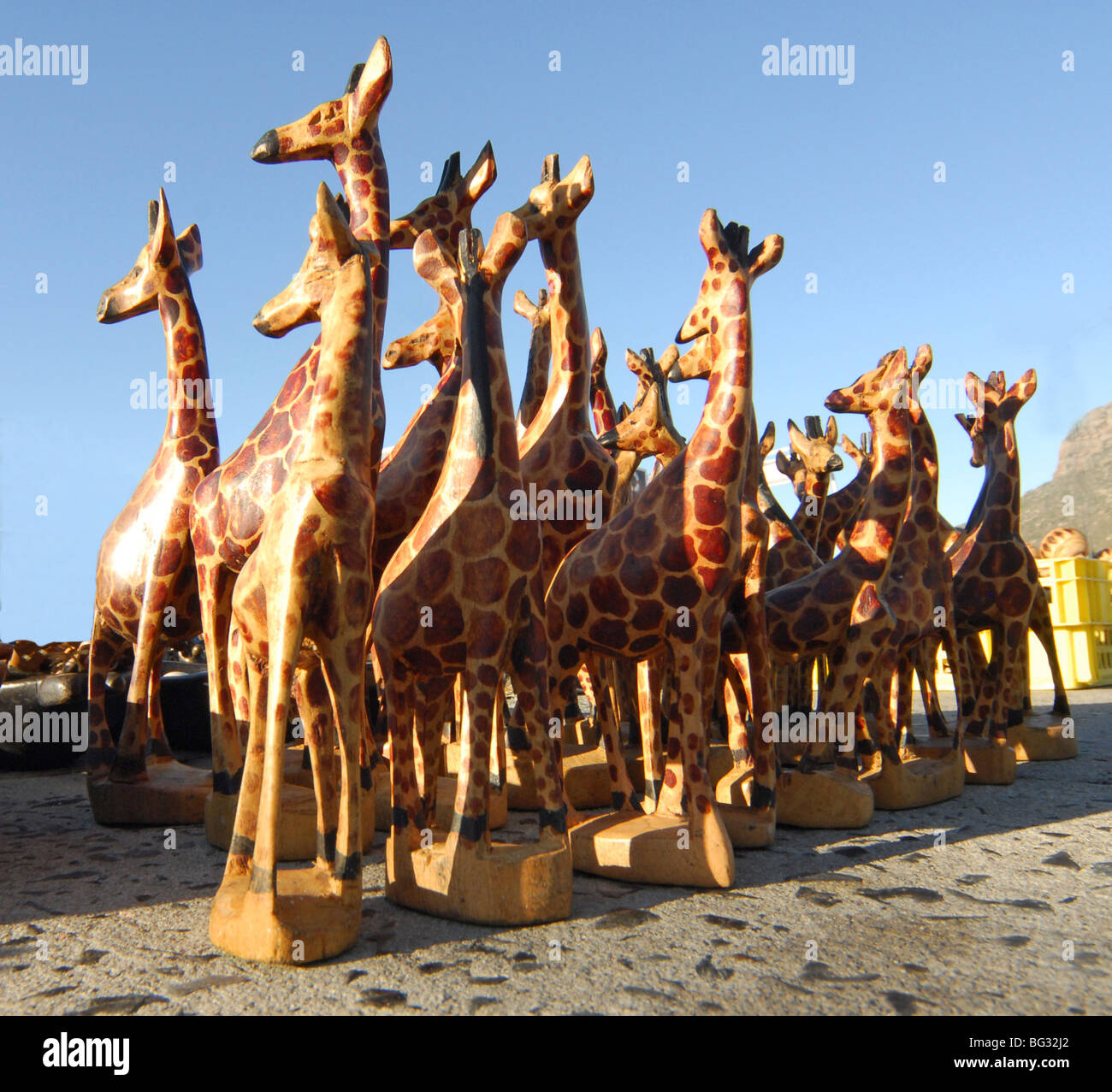 a group of hand carved wooden giraffes on sale at a market in Hout Bay, South Africa. Stock Photo